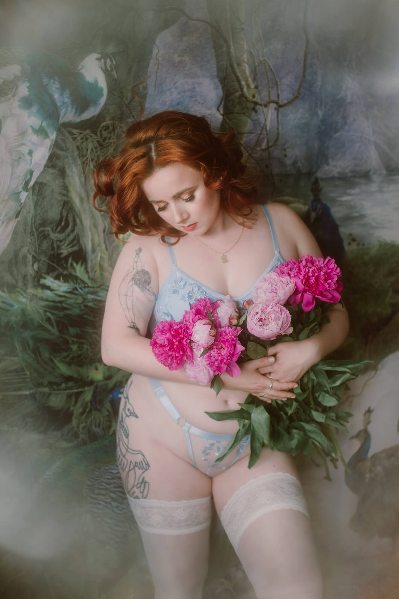 Fotografia sensualna, na której modelka w romantycznej bieliźnie i z kwiatami w rękach pozuje na abstrakcyjnym tle